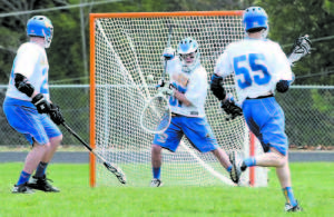 Ethan Green makes a stop in the Lake Region goal during boys' lacrosse action against Camden Hills last Saturday. On defense are Nick Hall (left) and Evan Kellough. (Rivet Photo)